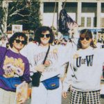 Three women in UW garb wave to the camera in a vintage photograph