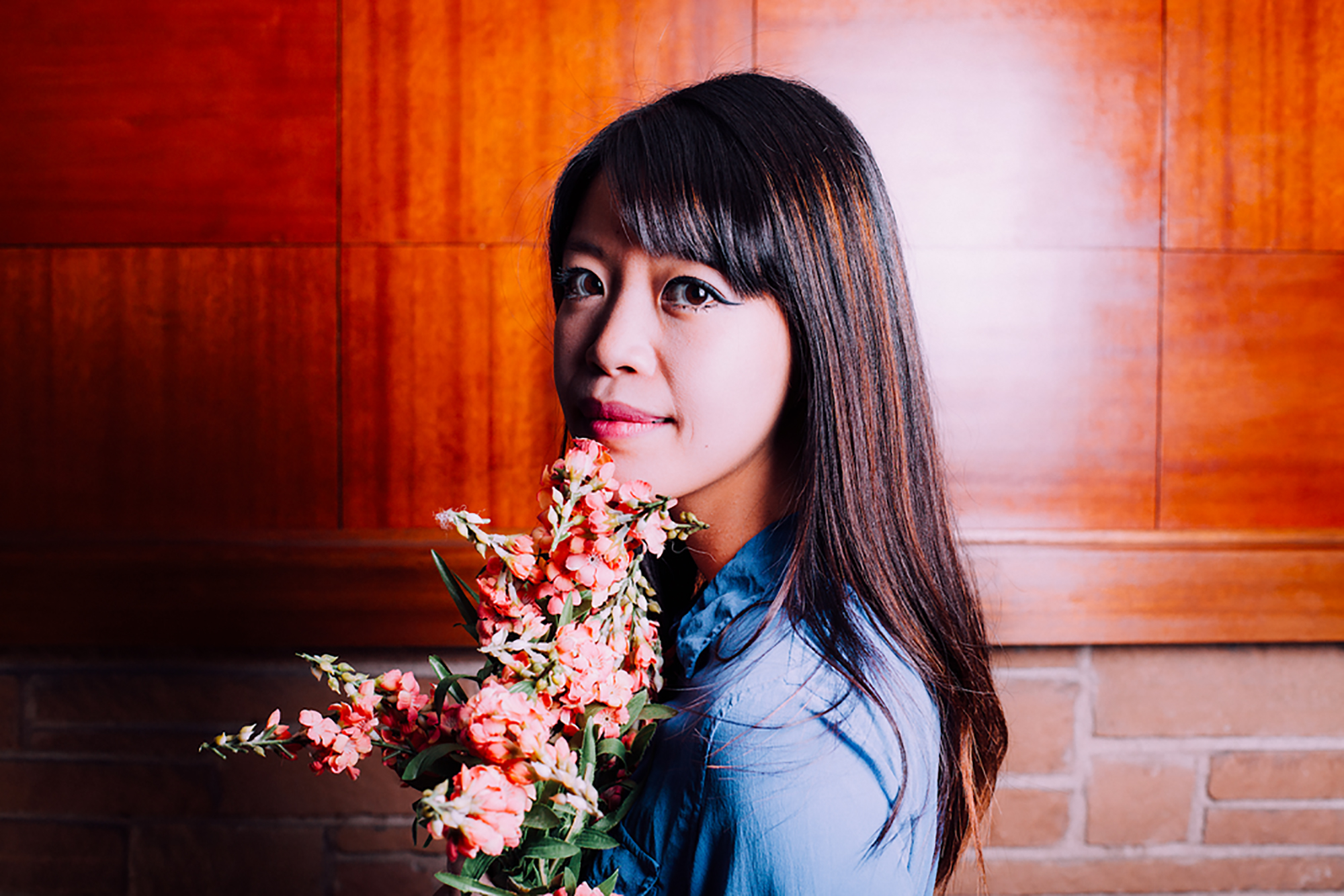 Headshot of Jane Wong holding a bouquet of flowers