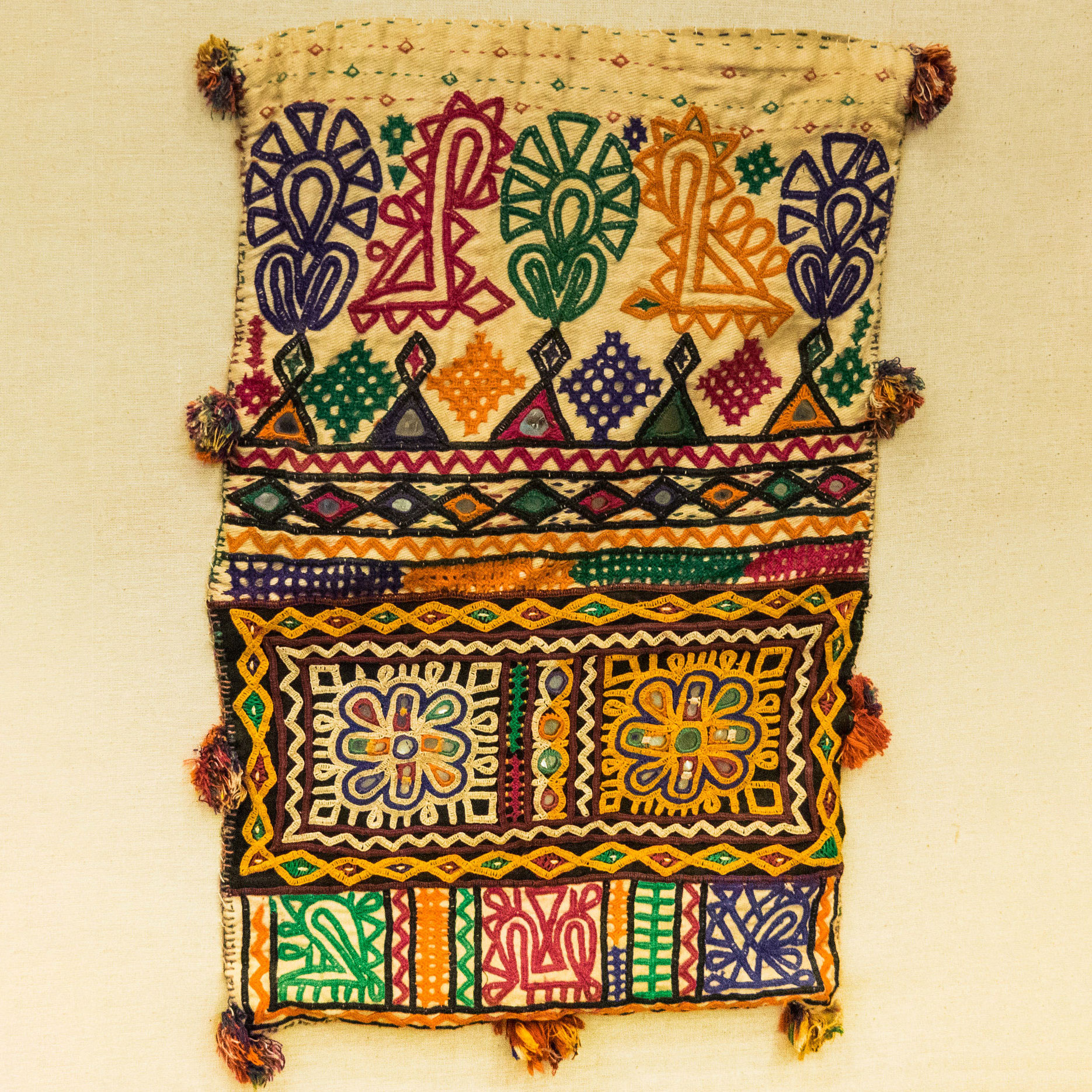 Tan cloth with many intricate colors embroidered