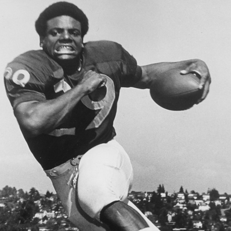 An archival black and white image of Harvy Blanks playing football at the UW