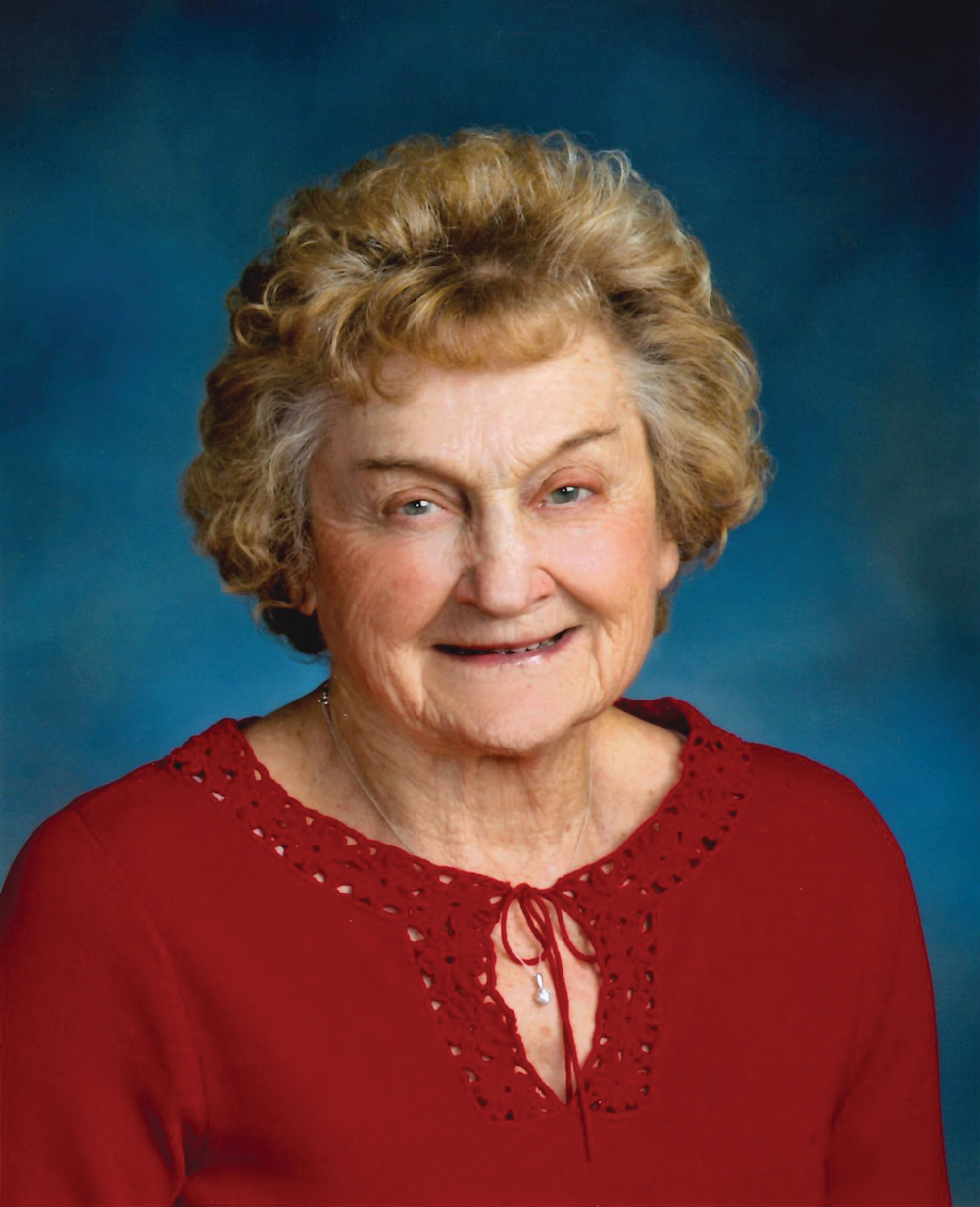 Elderly woman with blond hair and a red shirt smiling