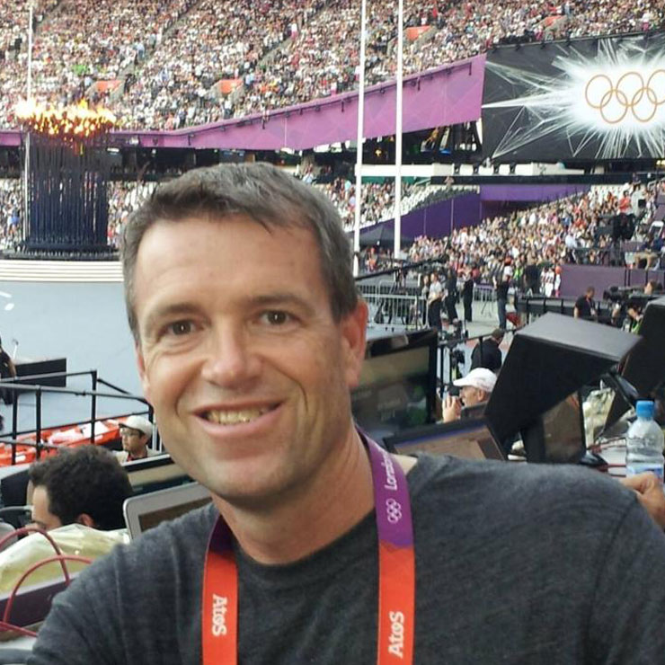 A man smiles in the crowd at the Olympics