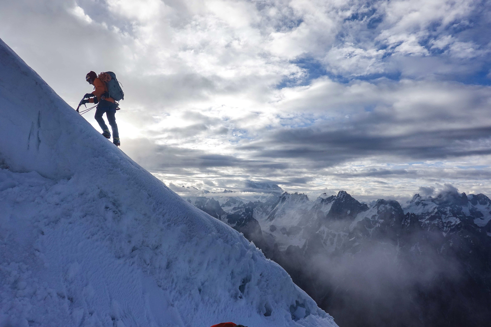 A man hikes a steep, snowy slope