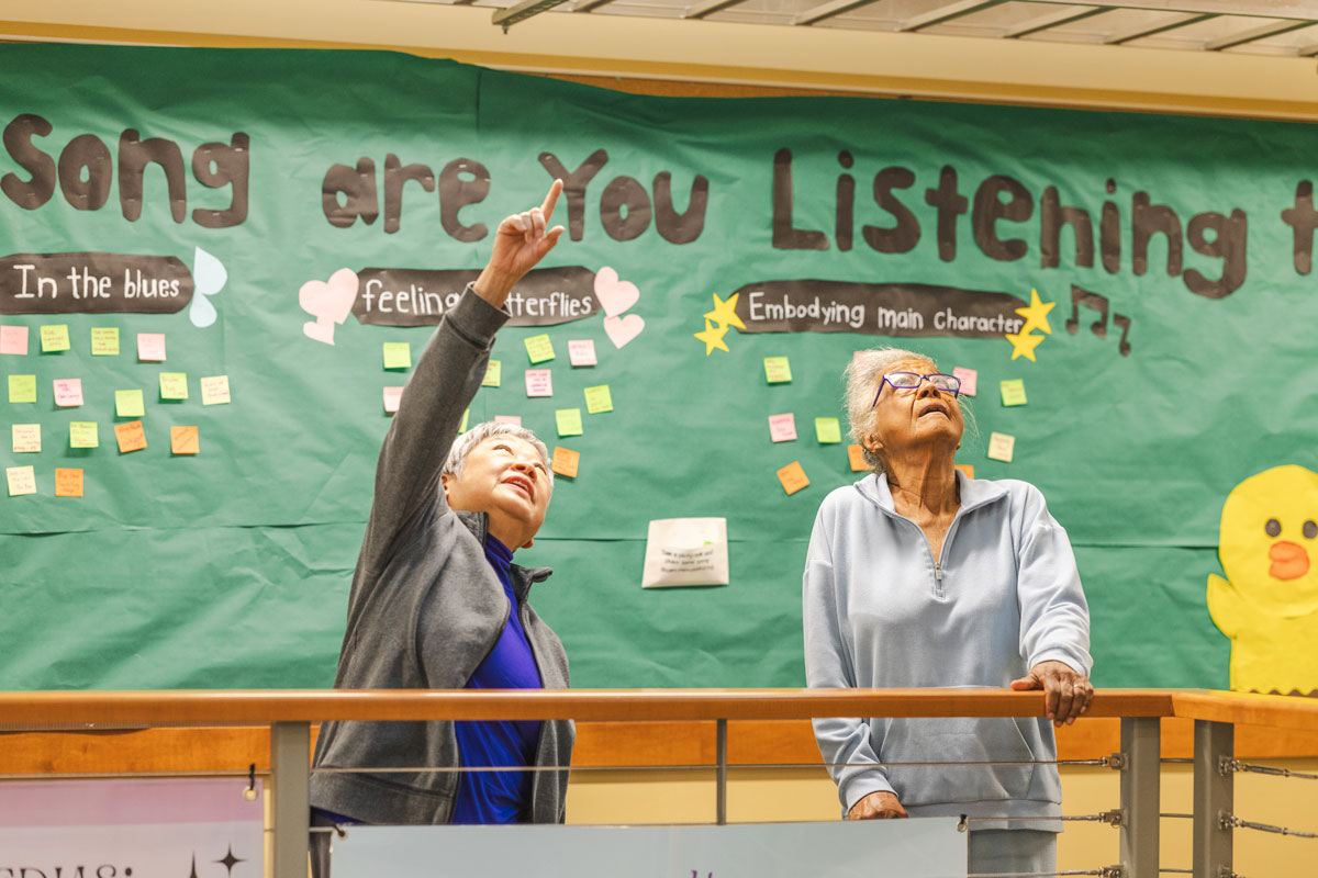 Two women stand in a school building looking up