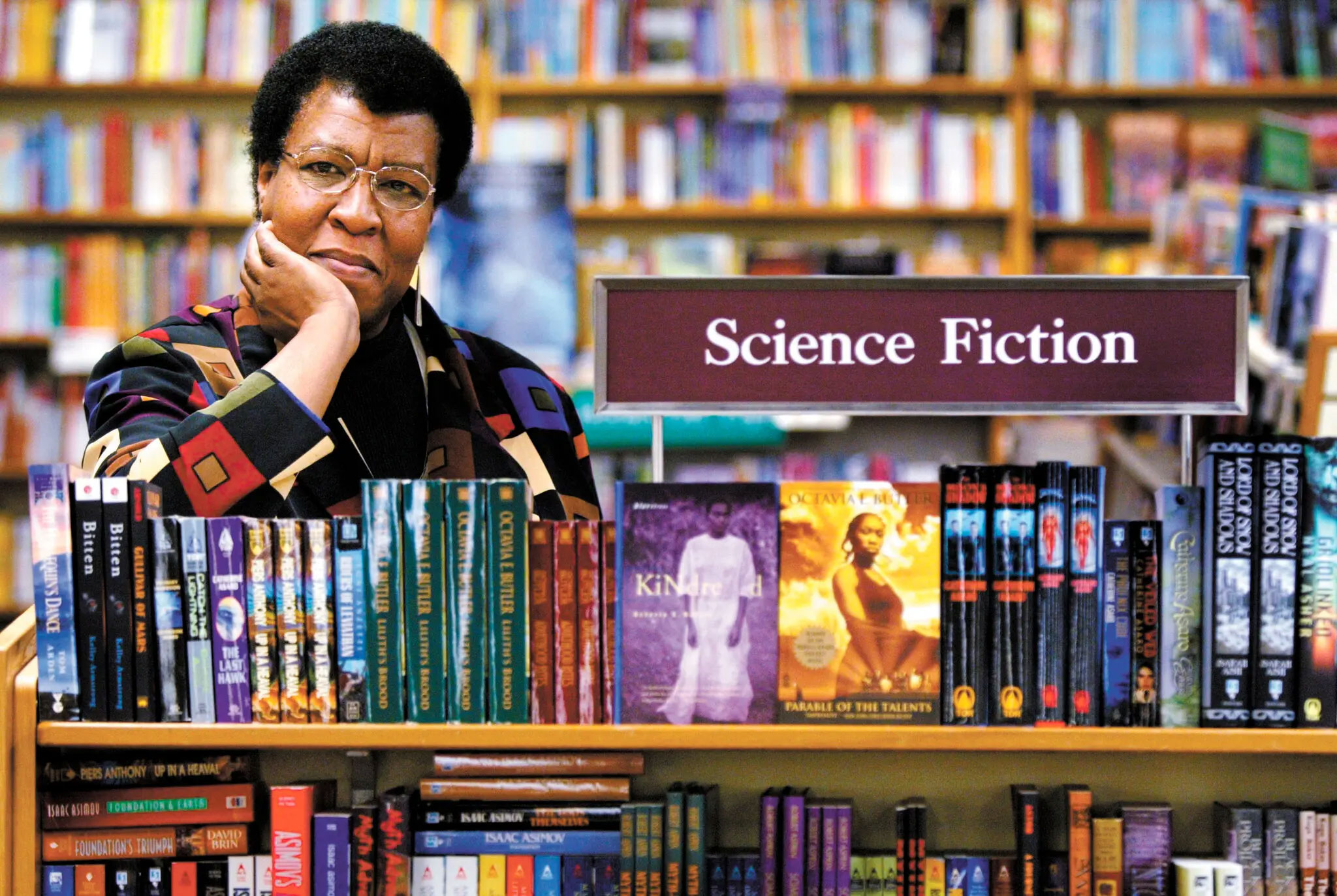 Octavia Butler poses with a stack of her own books in the Science Fiction section of the University Book Store.