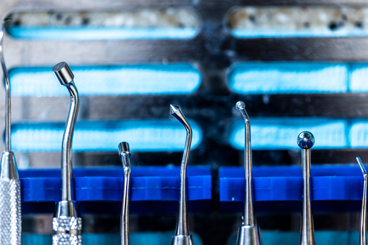 Various dental tools in focus against a blue background