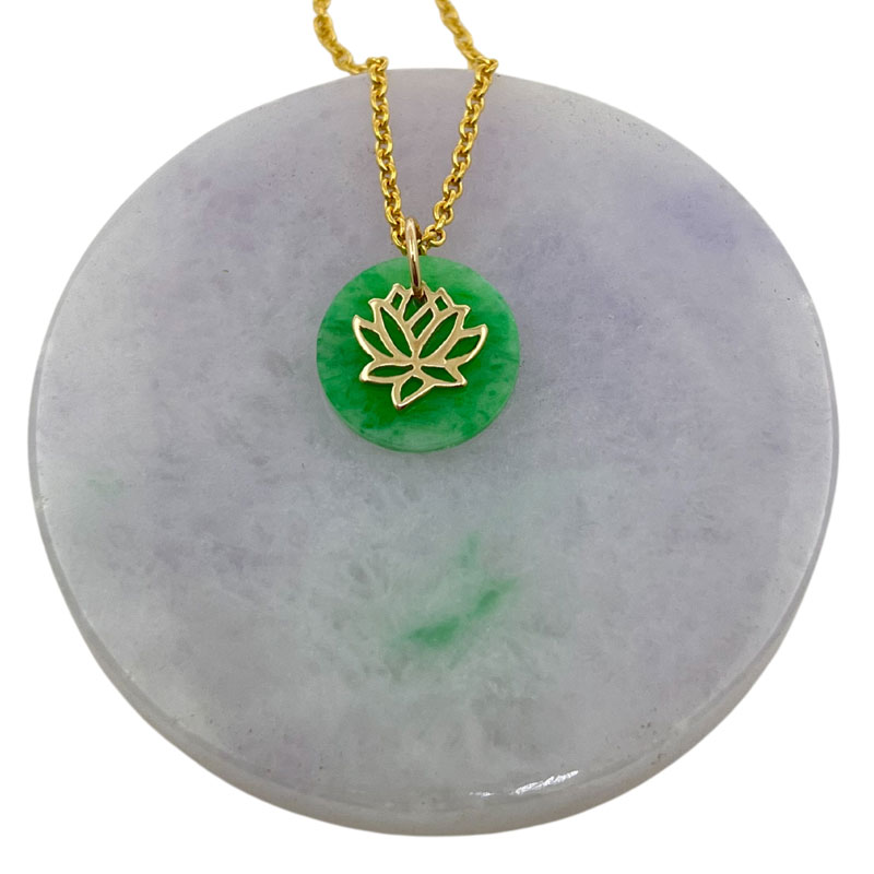 A green jade circular pendant with a gold lotus flower