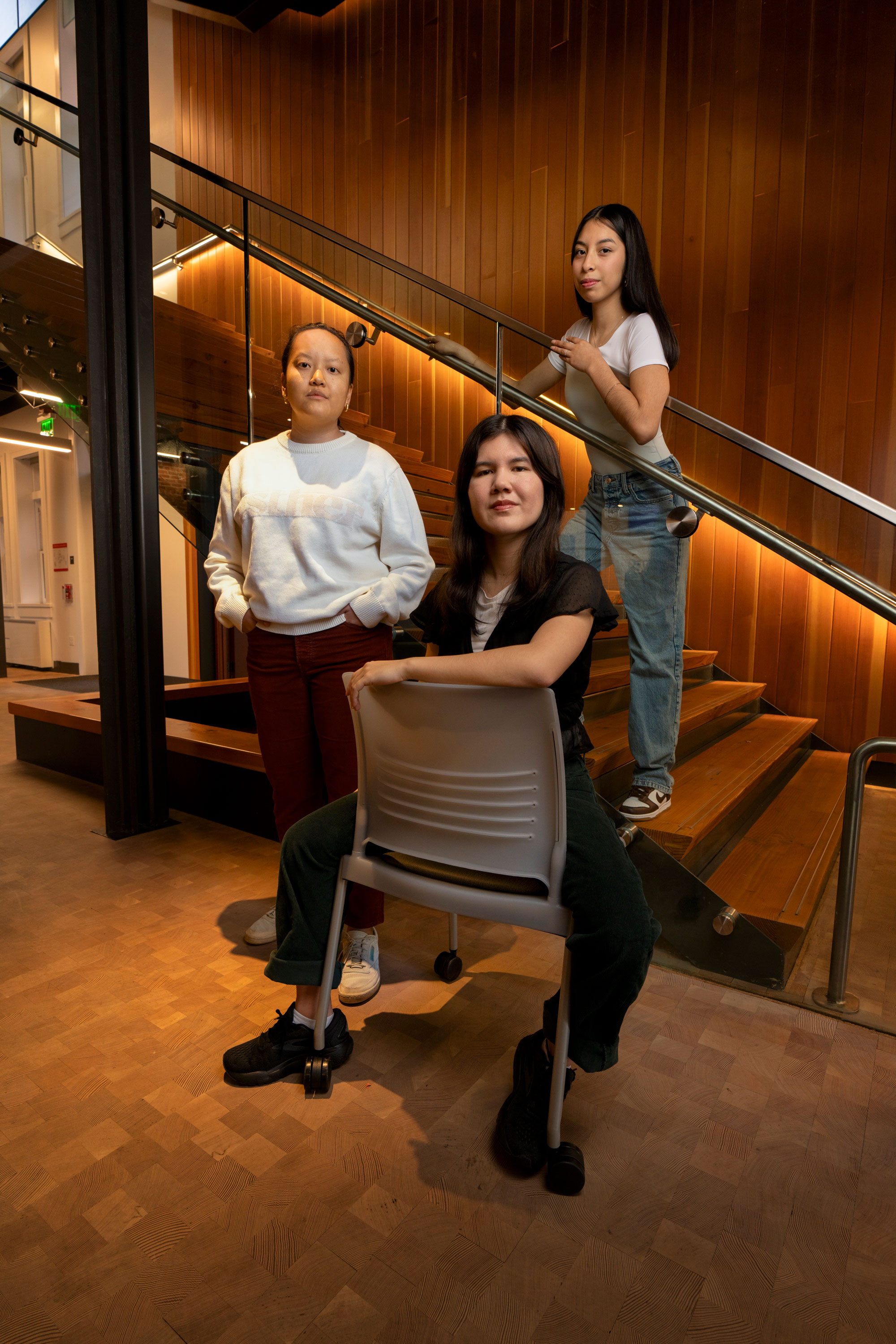 Three young women pose in a stairwell