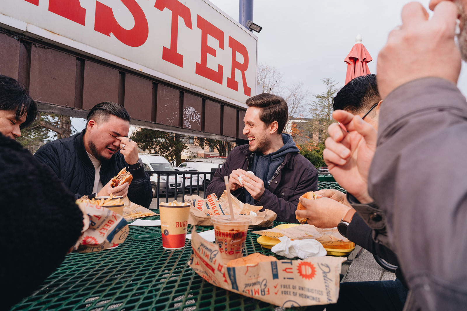 People laugh, cry and eat at the outdoor tables outside Burgermaster.