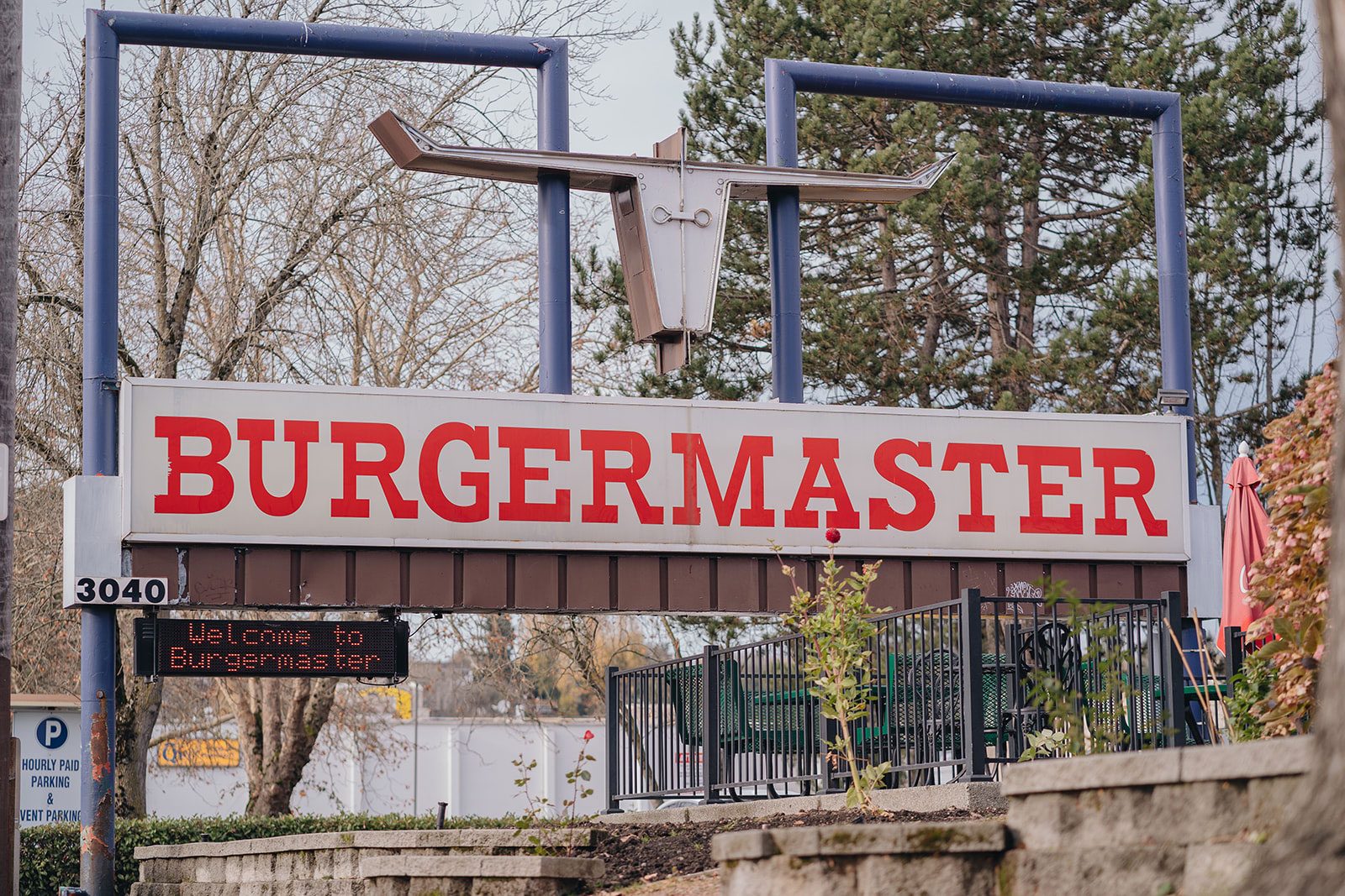 A mid-century-modern style sign reading "Burgermaster" with a minimalist silhouette of a steer framed by two blue squares.