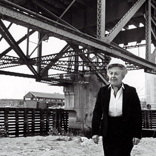 Seattle city councilmember Jeanette Williams stands near a construction site for the West Seattle Bridge wearing a hard hat.