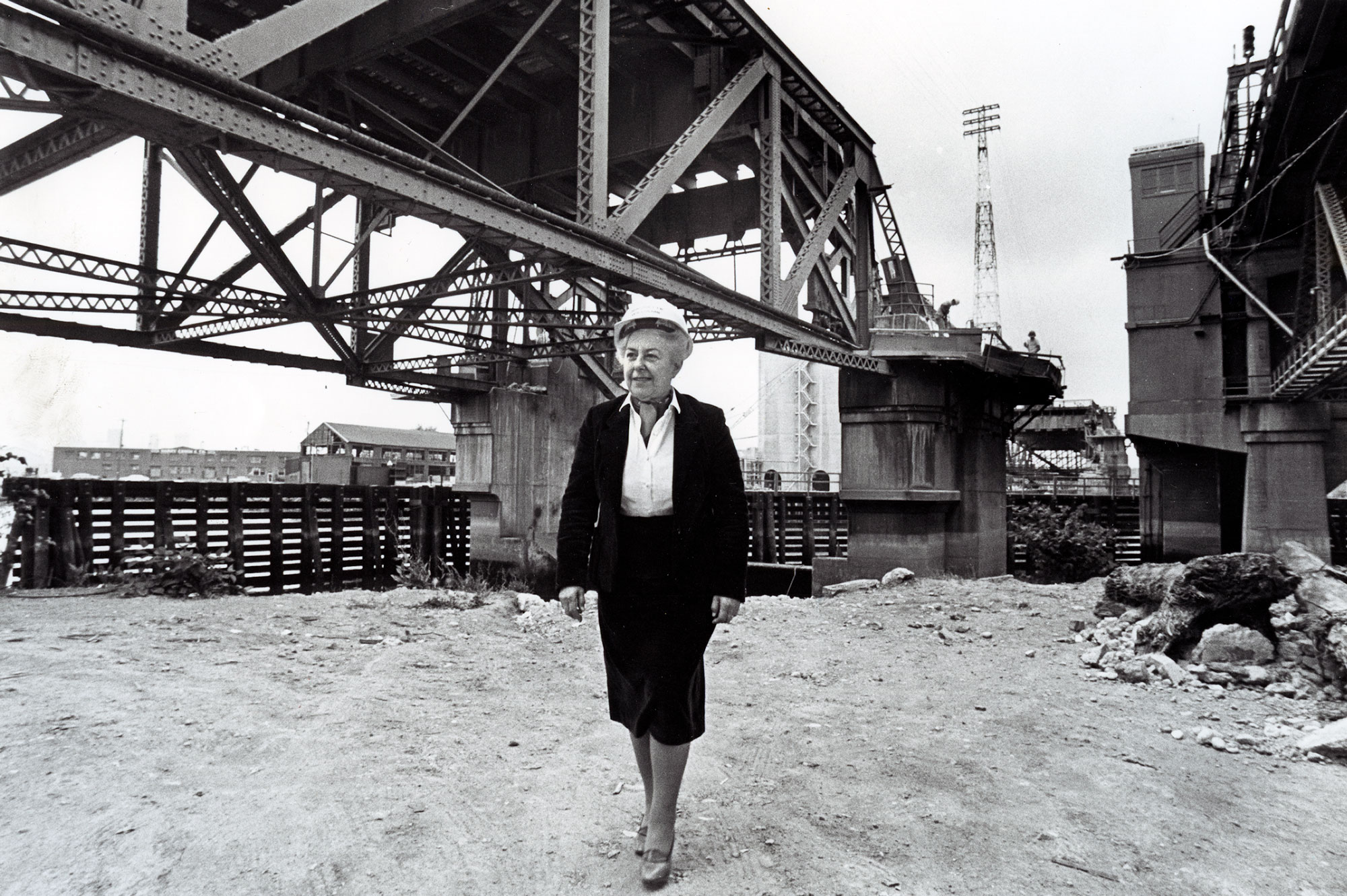 Seattle city councilmember Jeanette Williams stands near a construction site for the West Seattle Bridge wearing a hard hat.