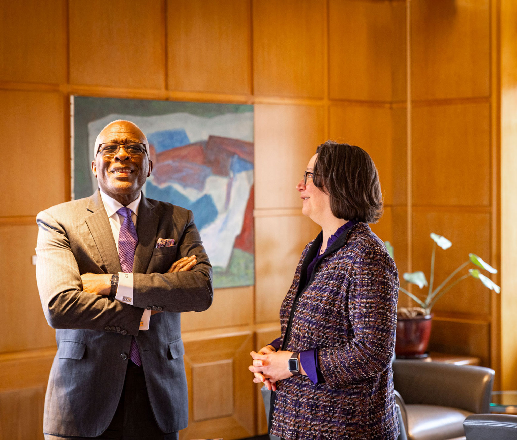 Dr. Robert Jones smiles and crosses his arms in an office next to Tricia Serio who folds her hands and looks on