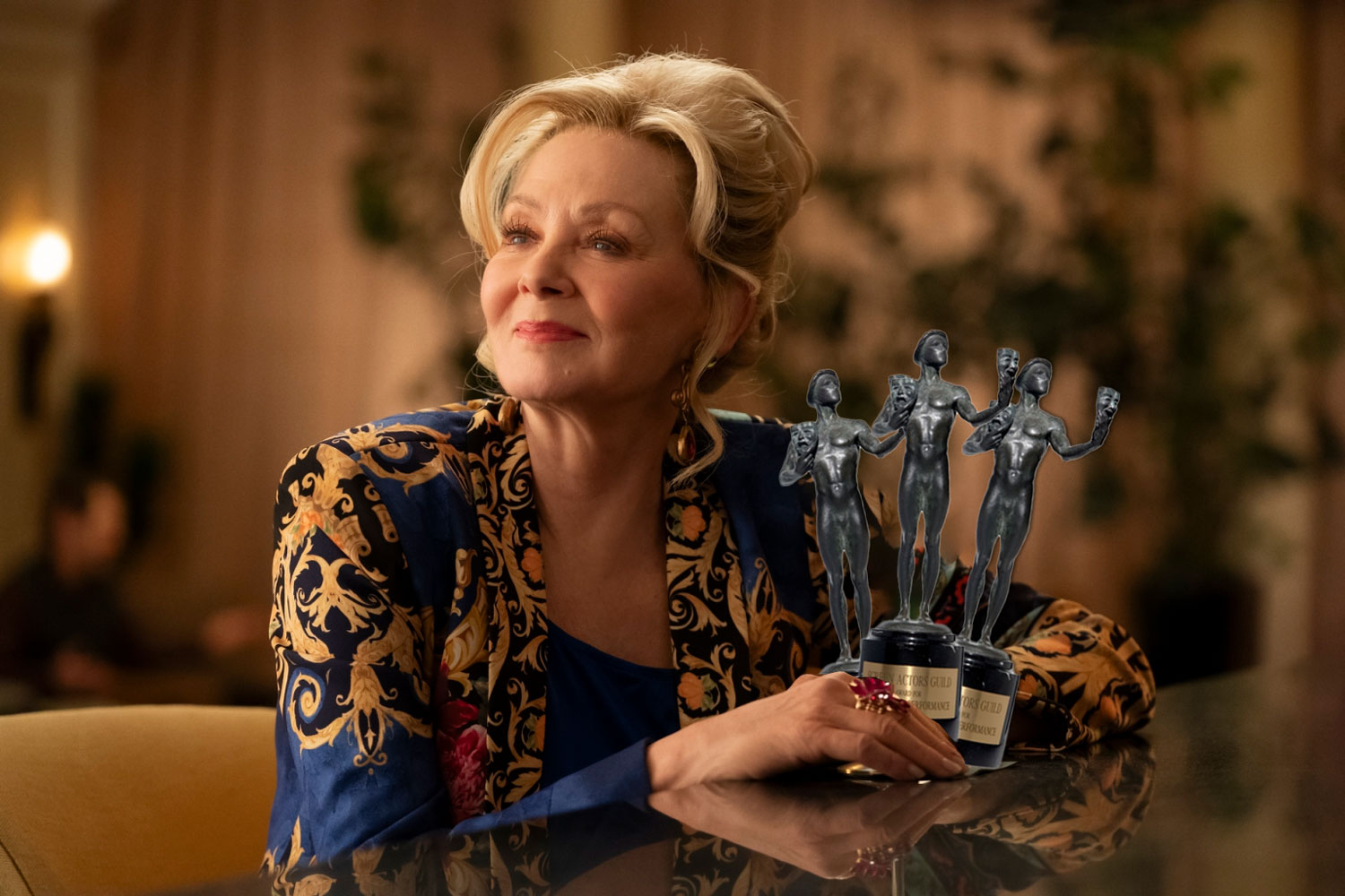 Jean Smart smiles at a bar with three SAG awards digitally added in her hands