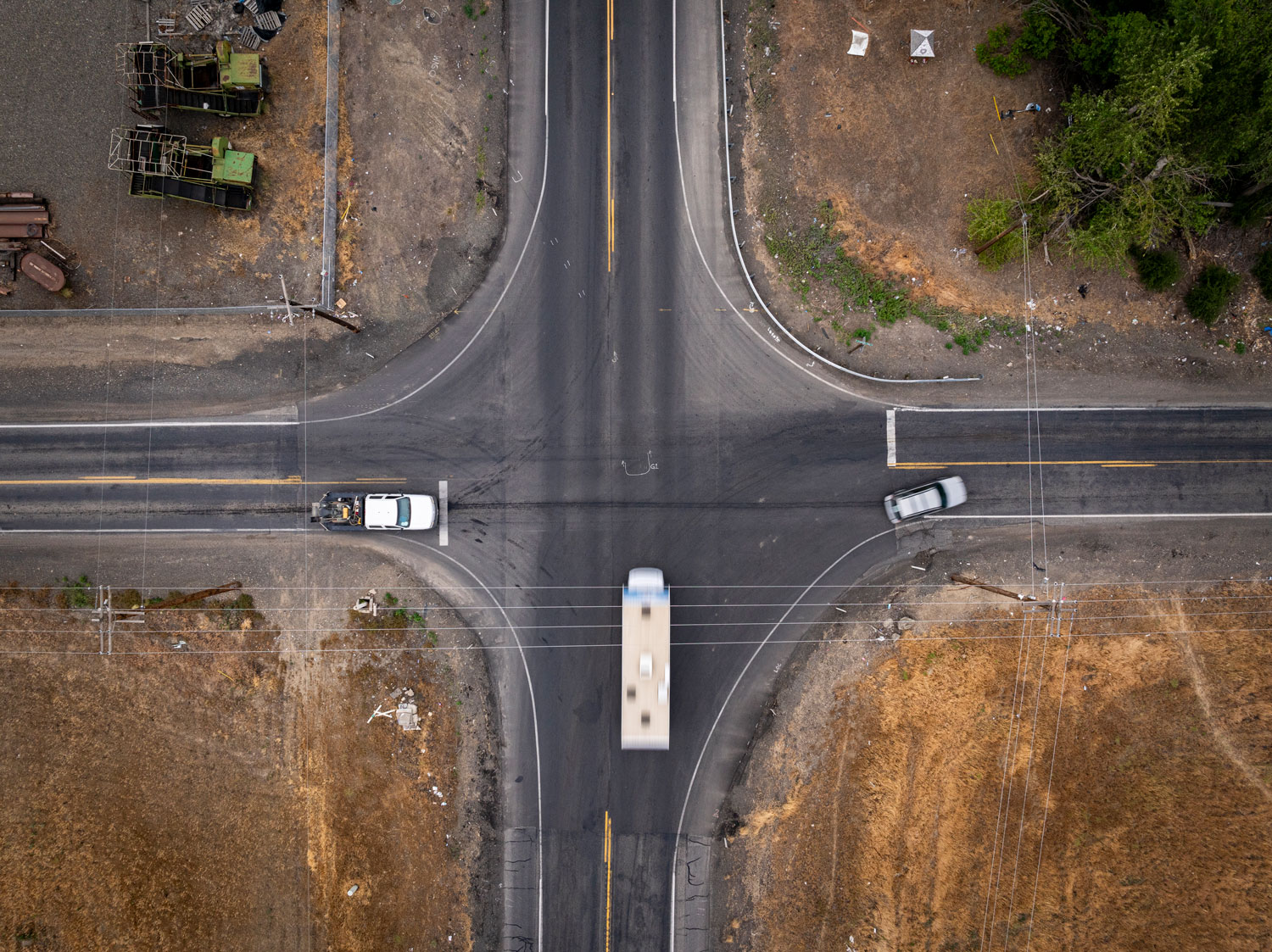 Aerial view of a highway intersection as a truck and two cars attempt to drive through it.