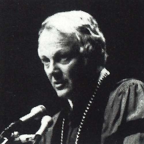 Black and white photo of former UW president Gerberding wearing robes and speaking into a microphone