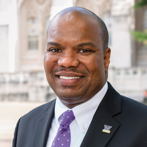 Rickey Hall standing on Red Square smiling wearing a purple tie