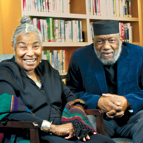 Lois and Thaddeus Spratlen sitting and smiling wearing formal attire