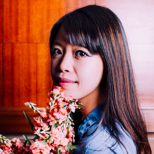 Headshot of Jane Wong holding a bouquet of flowers