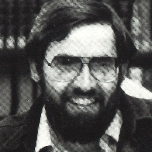 Headshot of David Kent smiling, wearing aviator glasses and a full beard