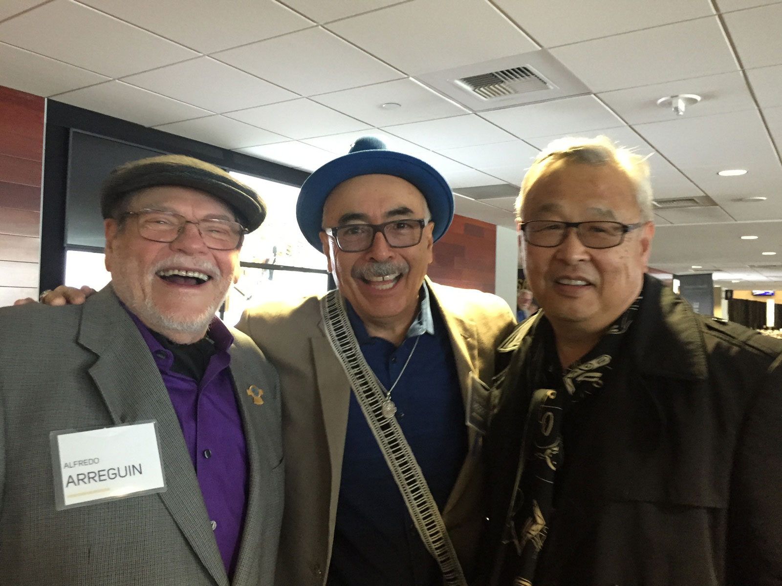 Three men smiling at an event