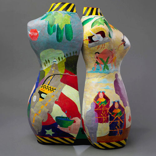 Two mannequins (without heads, arms or legs) painted with imagery of roads, people and objects.