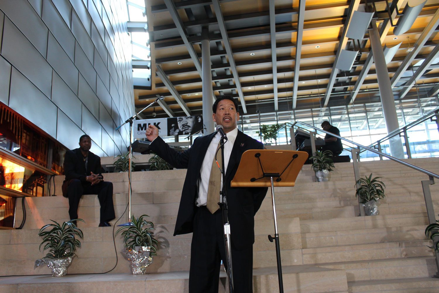 Bruce Harrell standing in front of a small lectern in a large assembly room
