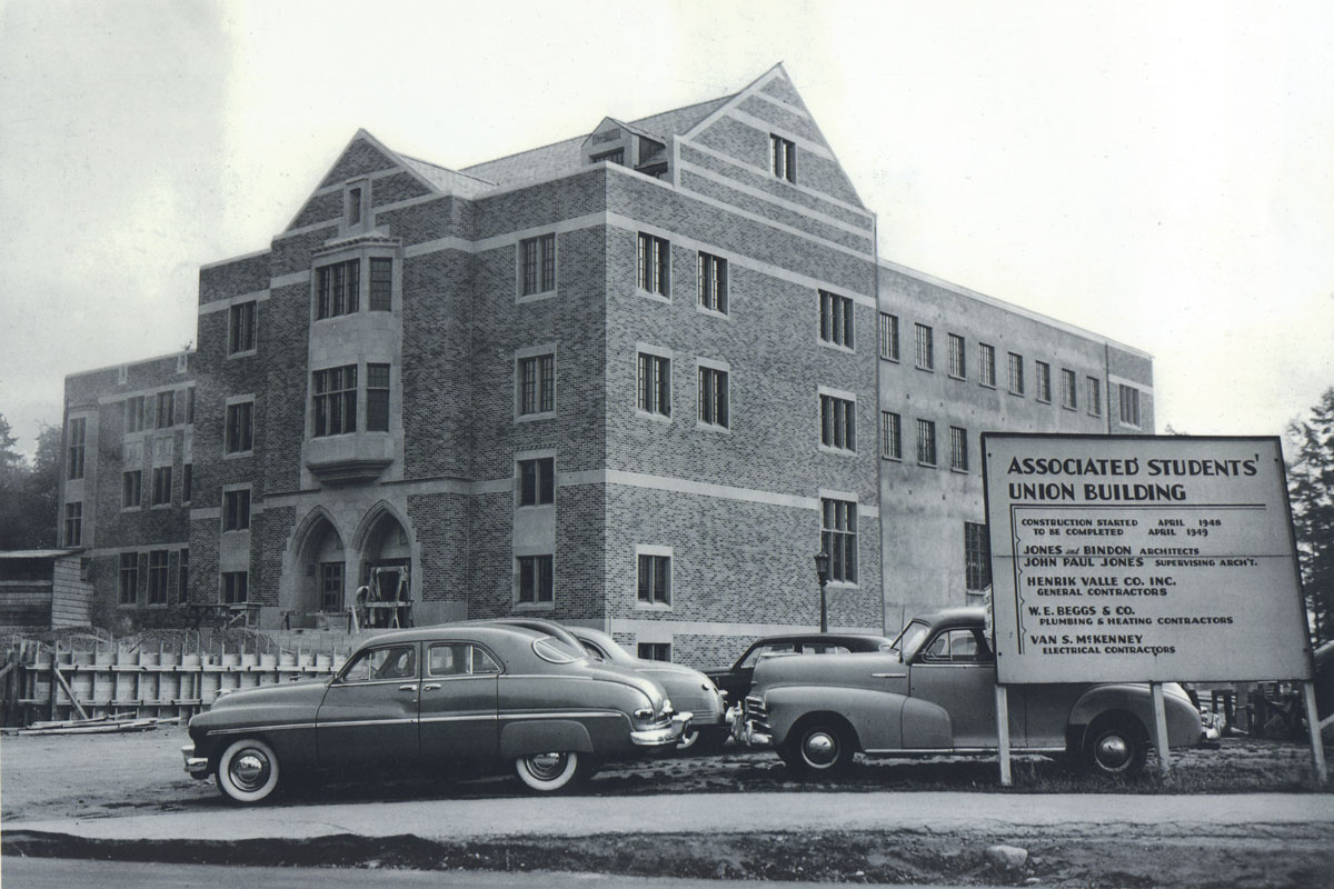 A film black and white photo of the Associated Students' Union Building with 1940s cars parked out front