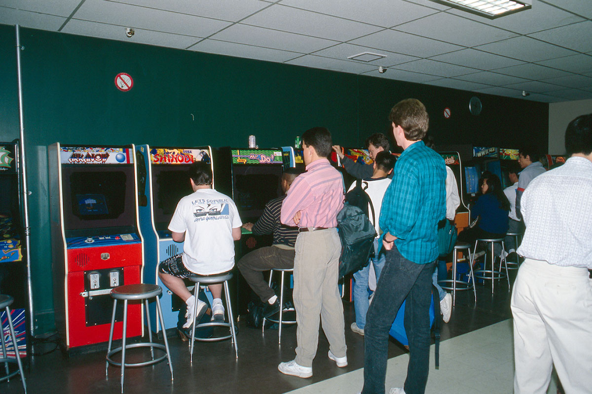 A group of men gather around arcade games in the Hub in the 1990s.