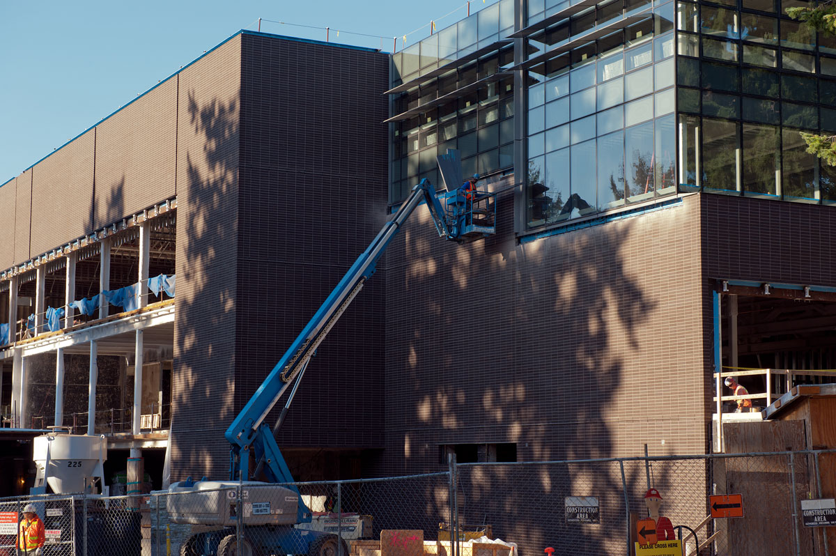 Outside the Hub, a large cherry picker construction tool lifts a man up to work on the windows of the building.