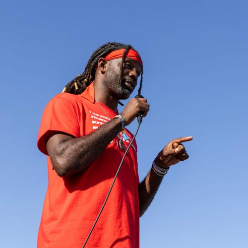 Bobby Jones speaks into a microphone on a sunny day