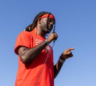 Bobby Jones speaks into a microphone on a sunny day