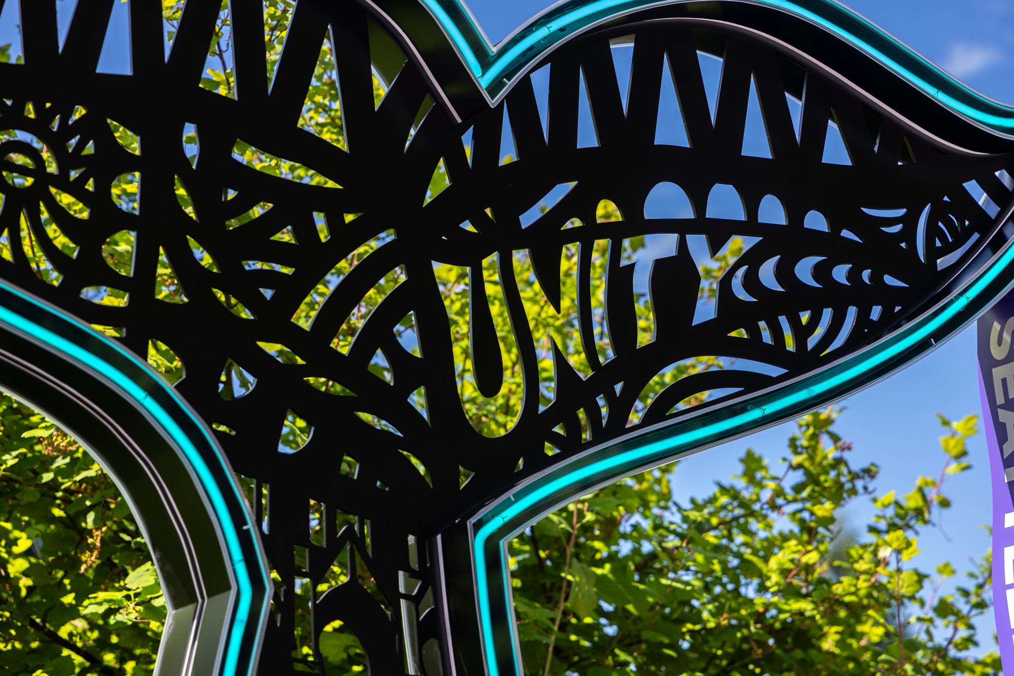 A large whale tail sculpture with neon lighting. The word 
