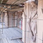 Intricately carved statue of Benjamin Franklin on the facade of Suzzallo Library, which is covered in scaffolding